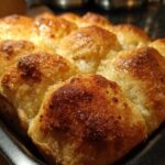 Close-up of golden-brown baked beef and bowtie pasta rolls in a baking dish.