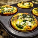 Close-up of freshly baked Cottage Cheese Egg Cups with Spinach & Feta in a muffin tin.