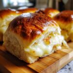 Close-up of a Ham and Cheese Slider with gooey melted cheese spilling out.