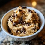 A bowl filled with delicious high protein cookie dough, studded with mini chocolate chips.