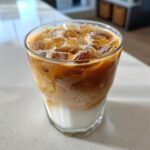 A refreshing iced coffee with milk and ice, perfect alongside cinnamon sugar cream cheese rolls.