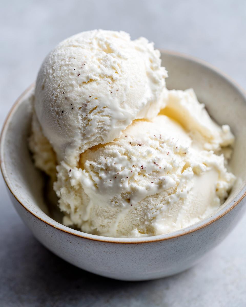 Close-up of creamy vanilla protein ice cream with visible vanilla bean specks in a bowl.