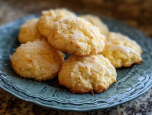 A stack of bright rigatoni bake cookies, drizzled with a white lemon glaze and sprinkled with lemon zest.