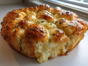 Close-up of cheesy hawaiian roll garlic bread with melted cheese and herbs, baked to a golden brown.