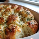 Close-up of cheesy Hawaiian roll garlic bread with melted cheese pulling apart and sprinkled with parsley.