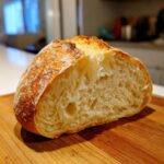 Close-up of the airy, open crumb structure inside a loaf of homemade french bread.