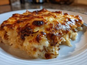 A close-up of a serving of French onion butter rice, featuring creamy rice topped with deeply browned, melted cheese.