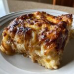 A close-up of a serving of French onion butter rice, baked with a deeply browned, cheesy topping and visible caramelized onions.
