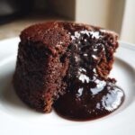 Close-up of a moist slice of chocolate pudding cake oozing with rich, dark chocolate sauce.