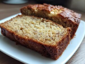 Close-up of two slices of ultra moist greek yogurt banana bread on a white plate.