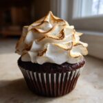 A single, rich chocolate cupcake topped with a swirl of toasted meringue frosting, perfect for hot chocolate cupcakes.