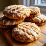 A stack of freshly baked coffee cake cookies topped with cinnamon streusel and a white vanilla glaze drizzle.