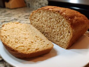 Close-up of a freshly baked whole wheat bread loaf, cut to show the soft, uniform crumb texture.