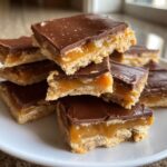 A stack of rich Caramel Ritz Cracker Christmas Cookies bars featuring a shortbread base, gooey caramel, and chocolate topping.