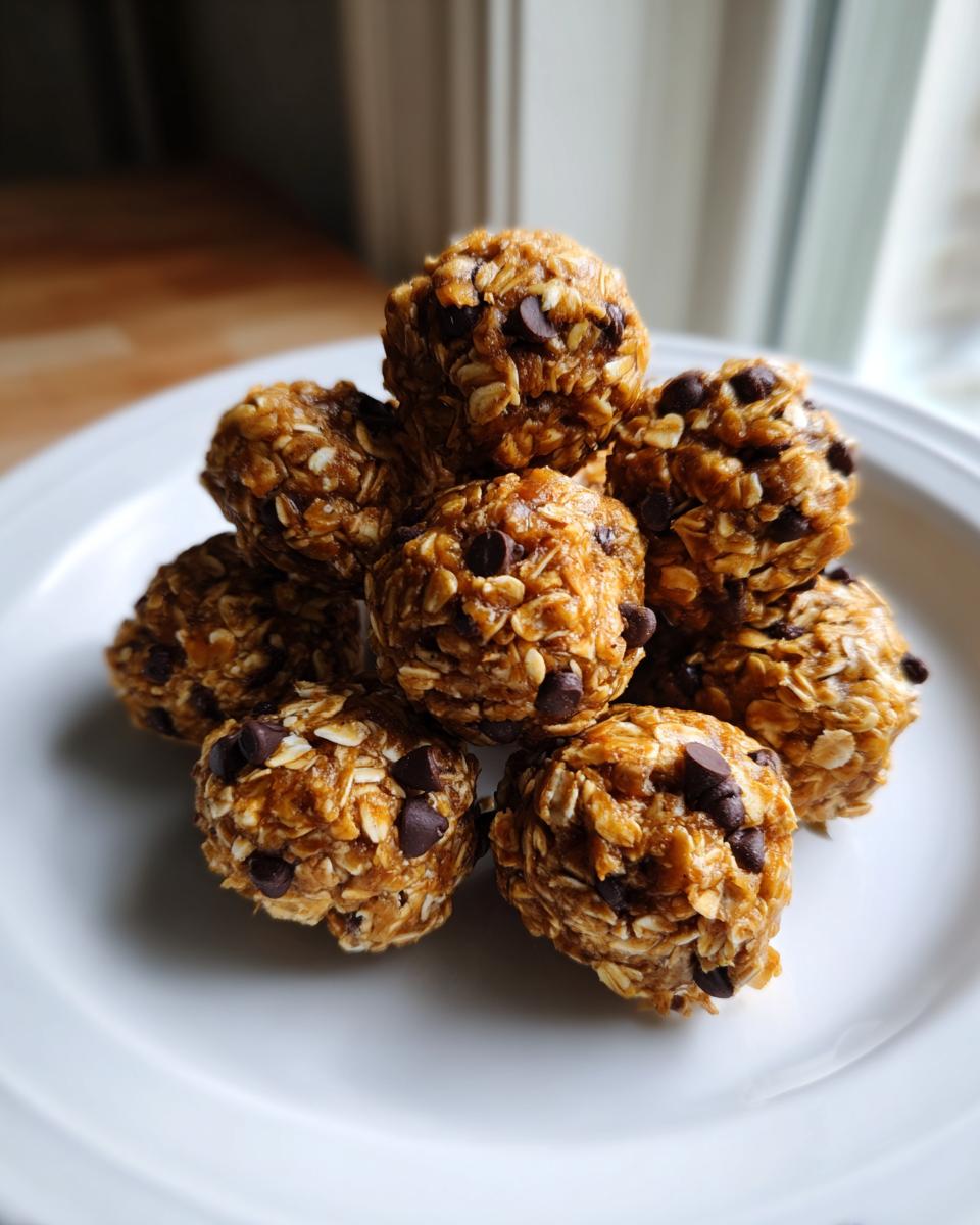 A stack of homemade, no-bake protein balls mixed with oats and mini chocolate chips resting on a white plate.