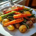 A close-up of roasted carrots, green beans, and baby potatoes seasoned with herbs for Garlic Herb Roasted Veggies.