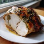 Close-up of a juicy herb butter turkey breast roast, showing the perfectly cooked white meat inside.